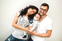 Hipster father, mother holding cute baby boy over white backgrou